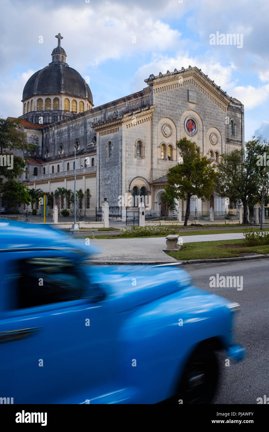 Havanna, Kuba - ca. März 2017: Alte klassische Auto fährt vor der historischen Kirche Jesús de Miramar. Stockfoto