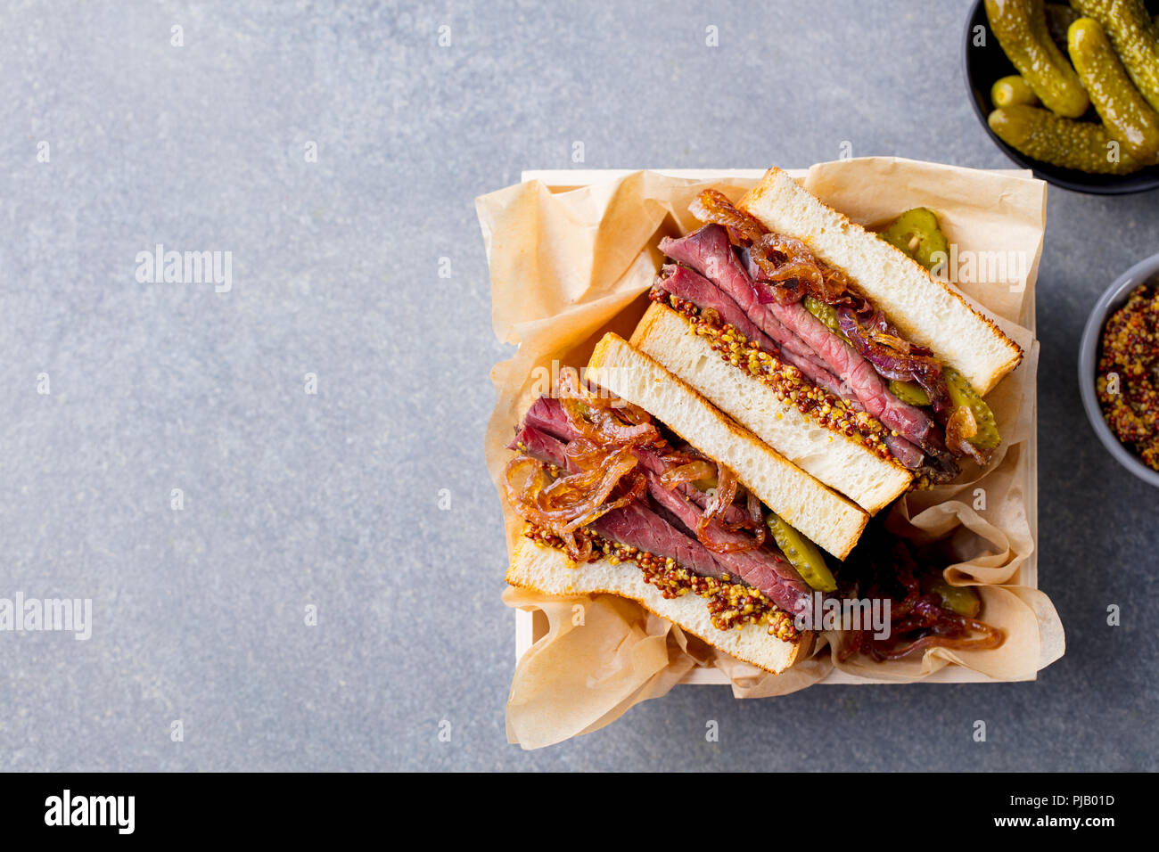 Sandwich mit Roastbeef in Holzkiste. Ansicht von oben. Kopieren Sie Platz. Stockfoto