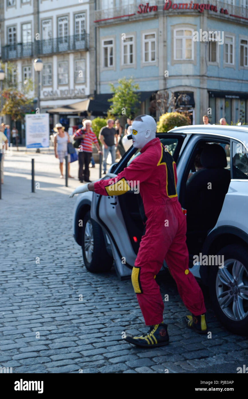 Fisura der Clown tritt in der Stadt Braga für das Noite Branca Event in Portugal auf. Clown verlässt ein weißes Auto. Stockfoto