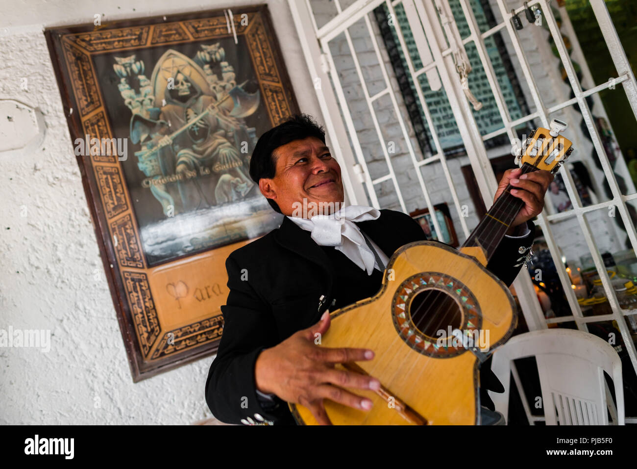 Ein mexikanischer Mariachi Musiker spielt Gitarre in der Santa Muerte (Heilige Tod) Tempel in Tepito, eine gefährliche Gegend von Mexico City, Mexiko. Stockfoto