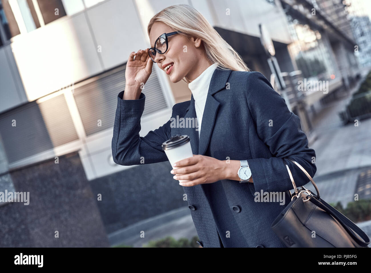 Freundliche weibliche Manager erhalten zu Fuß trinken Kaffee am Morgen zur Arbeit gehen, während die Walking Street, erfolgreiche Geschäftsfrau im eleganten Verschleiß sonniges Wetter genießen. Stockfoto