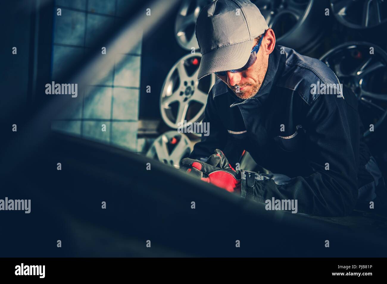 Kfz-Mechaniker Job. Kaukasische Fahrzeuge Techniker suchen unter der Haube. Stockfoto