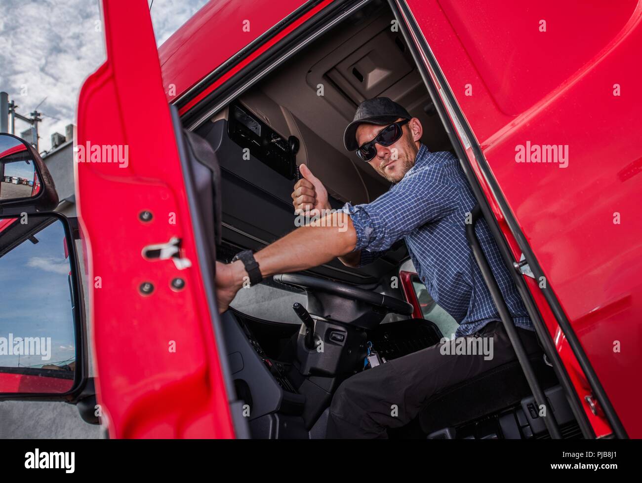 Happy kaukasischen Semi Truck Driver, Daumen hoch. Lkw-Thema. Transport Industrie. Stockfoto