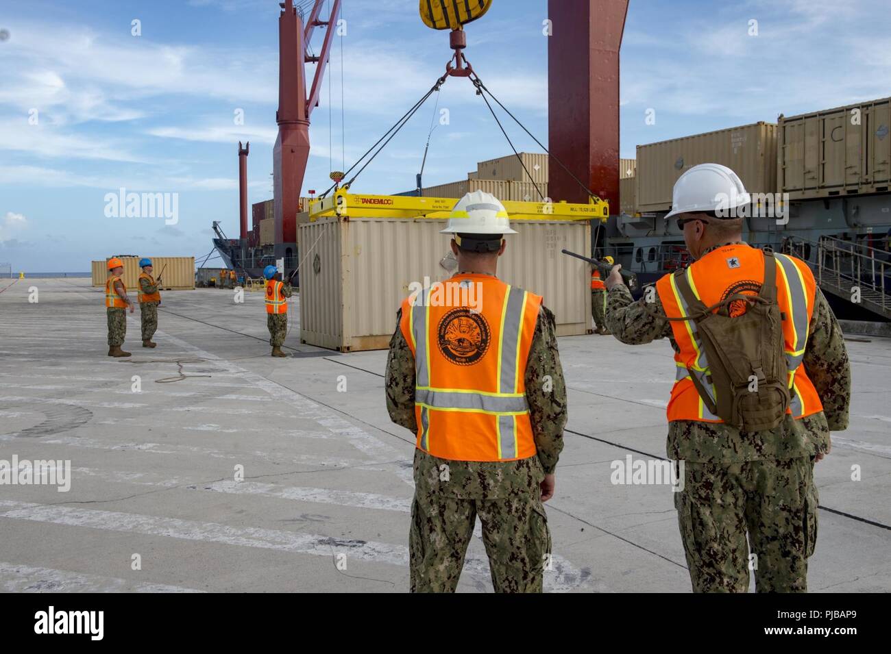 Segler zur Marine Cargo Handling Bataillon (NCHB) 1, Det zugeordnet. Guam, auf Ladung Munition, um die Dosen zu einem frachtschiff am Marinestützpunkt Guam, 2. Juli 2018. NCHB 1 Det. Guam, Commander, Task Force 75 zugeordnet, ist der Marine nur Active Duty cargo handling Bataillon, und ist eine schnell einsetzbare Bedieneinheit der Marine Expeditionary Combat Command, der fähig ist, Be- und Entladen von Schiffen und Flugzeugen in allen klimatischen Bedingungen und Bedrohung. Stockfoto