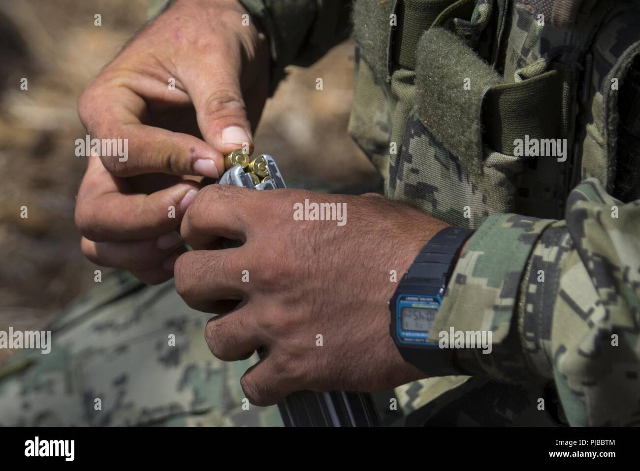 MARINE CORPS BASE CAMP Pendleton, Calif (3. Juli 2018) - eine mexikanische Marine mit den Amphibischen Marine Infantry Brigade lasten Runden in einem Magazin vor ein Brand während der Pacific Rim (Rimpac) Übung im Marine Corps Base Camp Pendleton, Kalifornien, 3. Juli 2018. RIMPAC zeigt den Wert der amphibischen Kräfte und bietet hochwertige Ausbildung für Task-organisierte, hoch-fähigen Marine Air-Ground Task Forces, die kritische Reaktion auf Krisen Fähigkeit der US-Streitkräfte und Partner weltweit verbessern. 25 Nationen, 46 Schiffe, 5 U-Boote, über 200 Flugzeuge und 25.000 Perso Stockfoto