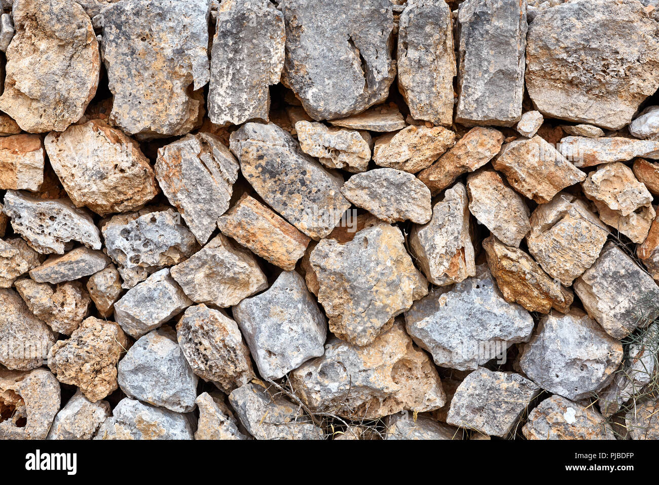 Alte Mauer aus vulkanischen rauen Felsen, natürliche Hintergrund oder Textur. Stockfoto