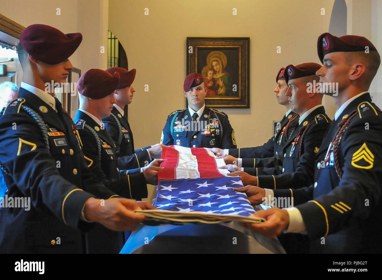 Die Flagge der Vereinigten Staaten ist in den Sarg des Verstorbenen Pensionierten 1 Sgt gefaltet. Harold Eatman durch Fallschirmjäger des 2 Battalion, 505Th Parachute Infantry Regiment am 11. Juli 2018 in der Kathedrale von Saint Patrick in Charlotte, North Carolina als 1. Sgt. James Miller von Firma B, 2-505 PIR, Mitte, schaut an. Eatman war Mitglied der 505th PIR und vier Zweiten Weltkrieg bekämpfen springt in Sizilien, Salerno, die Normandie und Holland mit dem Regiment. Er starb bereits im Juli im Alter von 102 Jahren. Stockfoto