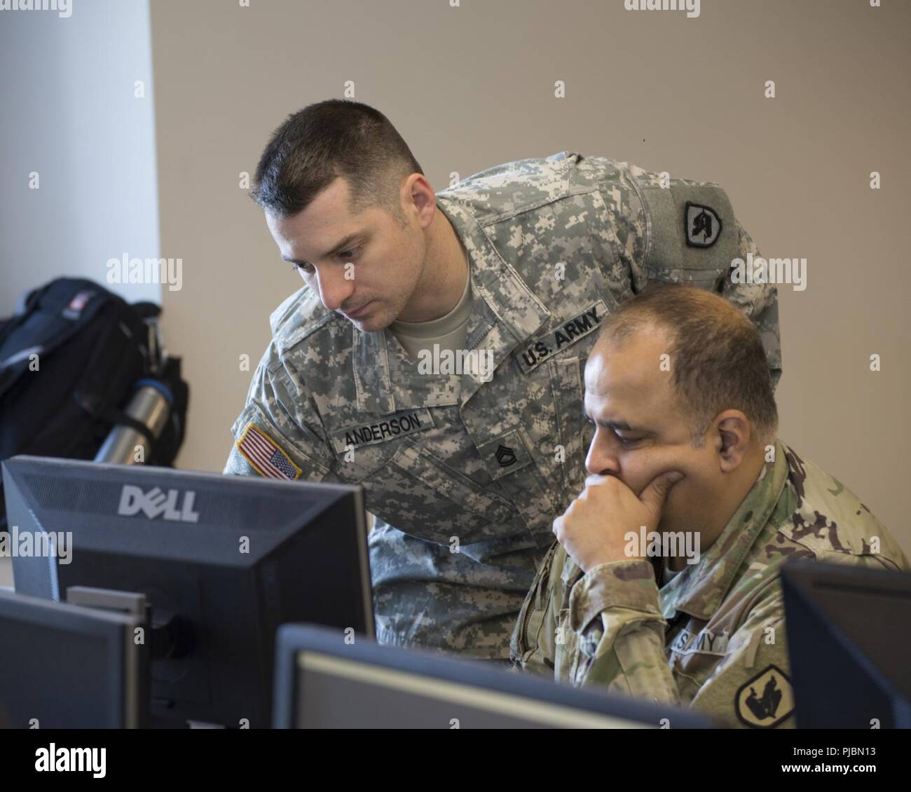 Sgt. 1. Klasse Samuel Anderson, Joint Force Headquarters, Washington National Guard, berät Cpt. Sameer Puri, 56 Theater Information Operations, während der Internationalen Stiftskirche Cyber Defense Einladungs, 6. Juli 2018, bei Highline Community College in Des Moines, Washington Washington National Guard Soldaten nahmen an der Internationalen Stiftskirche Cyber Defense Einladungs zu helfen, Informationstechnologie Studenten auf ihre Antworten auf Cyberangriffe erziehen. Stockfoto