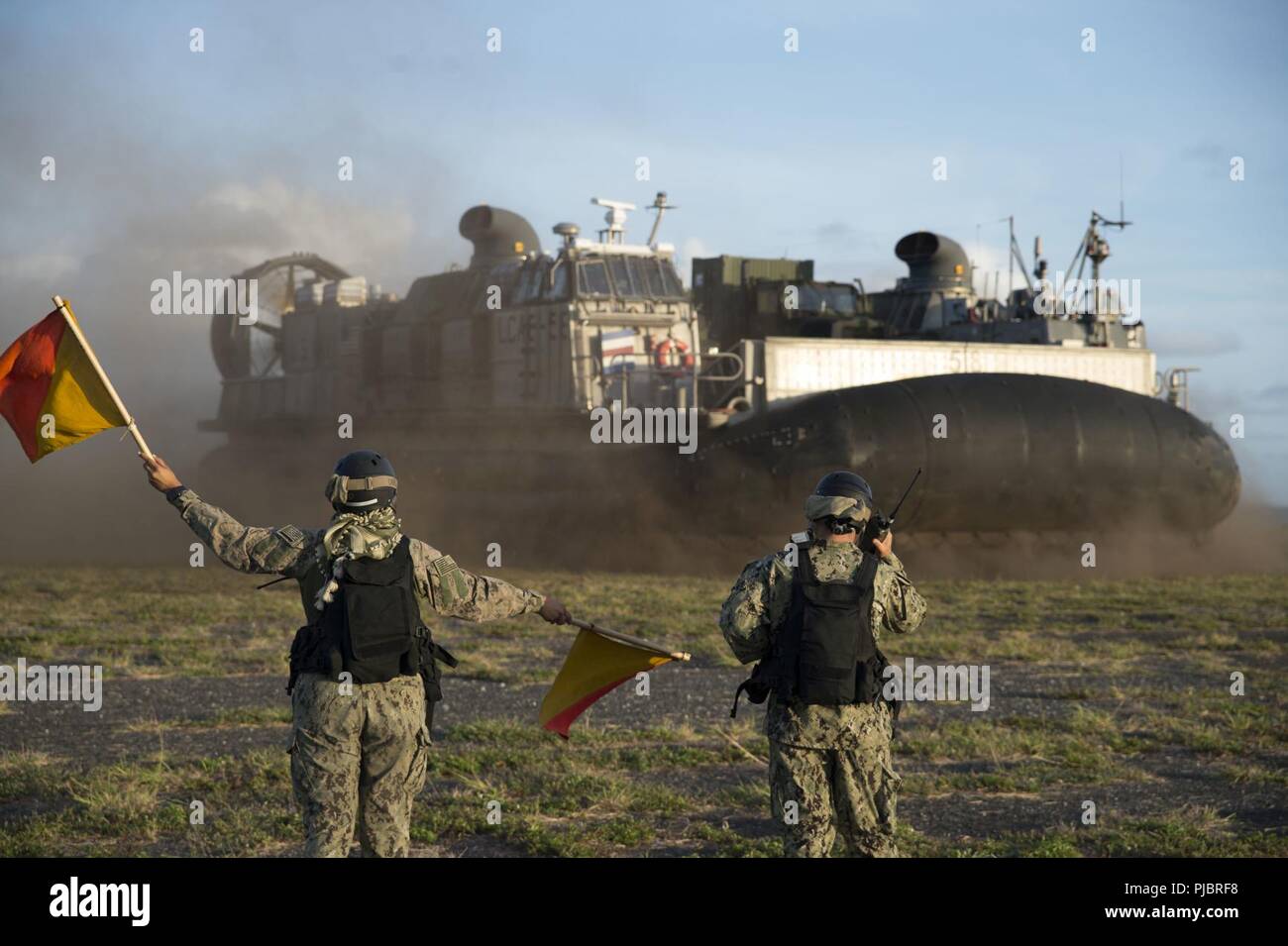 MARINE CORPS BASE HAWAII, (12. Juli 2018) 3.Klasse Engineman Yanet Carrillo, links, von Port Arthur, Texas, und der Chief Bootsmann Mate Tschad Nevis, von Stockton, Kalifornien, sowohl zum Strand Master Unit (BMU) 1, direkter Landing Craft air cushion (LCAC) 58 als Teil der Ship-to-Shore, die zwischen den in der Amphibisches Schiff USS BONHOMME RICHARD (LHD 6) und Marine Corps Base Hawaii während der 2018 Rand des Pazifik (Rimpac) Übung zugewiesen. 25 Nationen, 46 Schiffe, 5 U-Boote, über 200 Flugzeuge und 25.000 Angestellte beteiligen sich an Rimpac vom 27. Juni bis 2. August in und um die Stockfoto