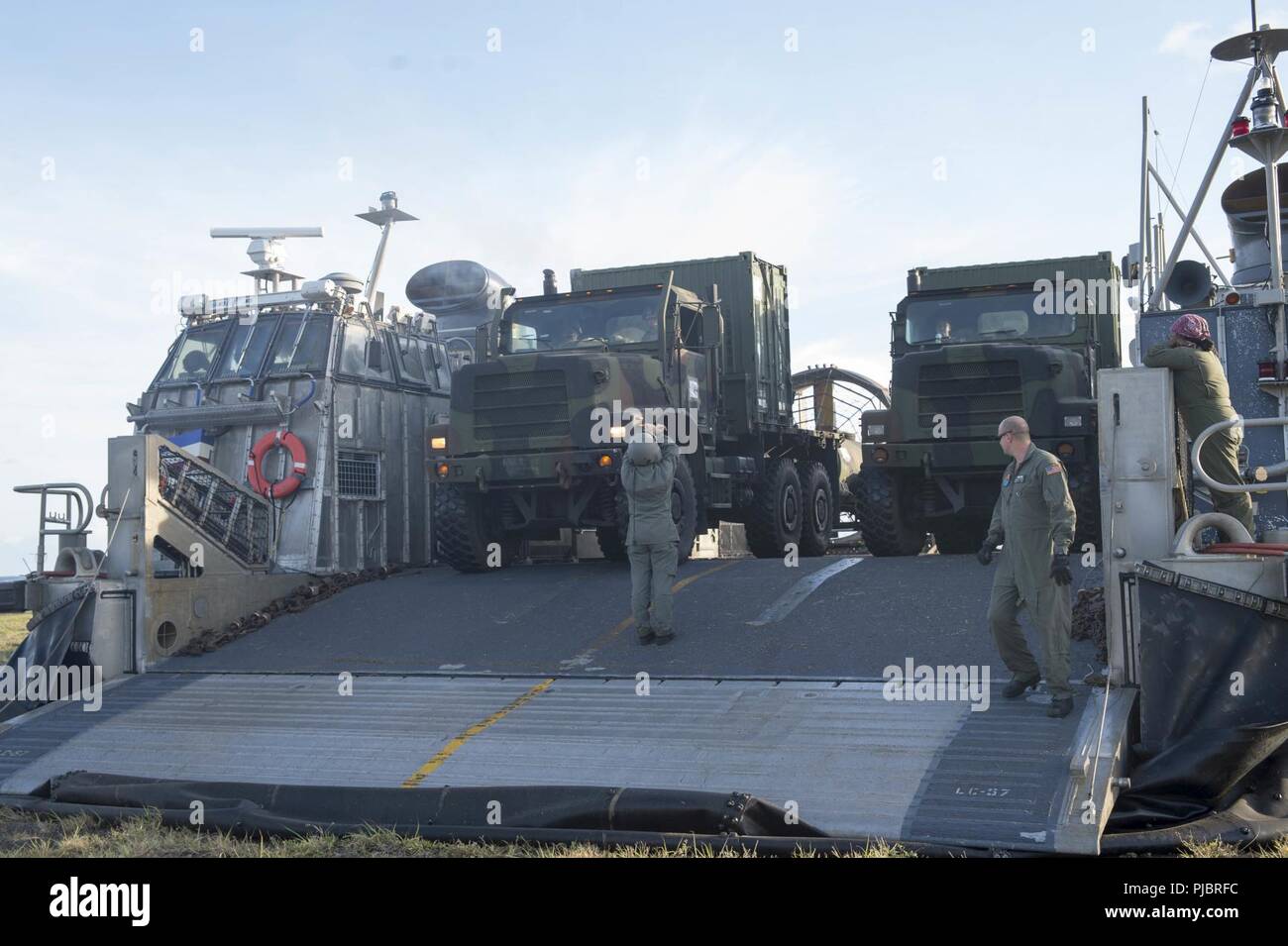 MARINE CORPS BASE HAWAII, (Juli 12, 2018) der Bootsmann Mate 3. Klasse Rachel Johnson, zugeordnet zu den Angriff Craft Unit (ACU) 5 Fahrzeuge auf Landing Craft air cushion leitet (LCAC) 57 zur Unterstützung der Ship-to-Shore, die zwischen den in der Amphibisches Schiff USS BONHOMME RICHARD (LHD 6) und Marine Corps Base Hawaii während der 2018 Rand des Pazifik (Rimpac) Übung. 25 Nationen, 46 Schiffe, 5 U-Boote, über 200 Flugzeuge und 25.000 Angestellte beteiligen sich an Rimpac vom 27. Juni bis 2. August in und um die hawaiischen Inseln und Südkalifornien. Die weltweit größte internati Stockfoto