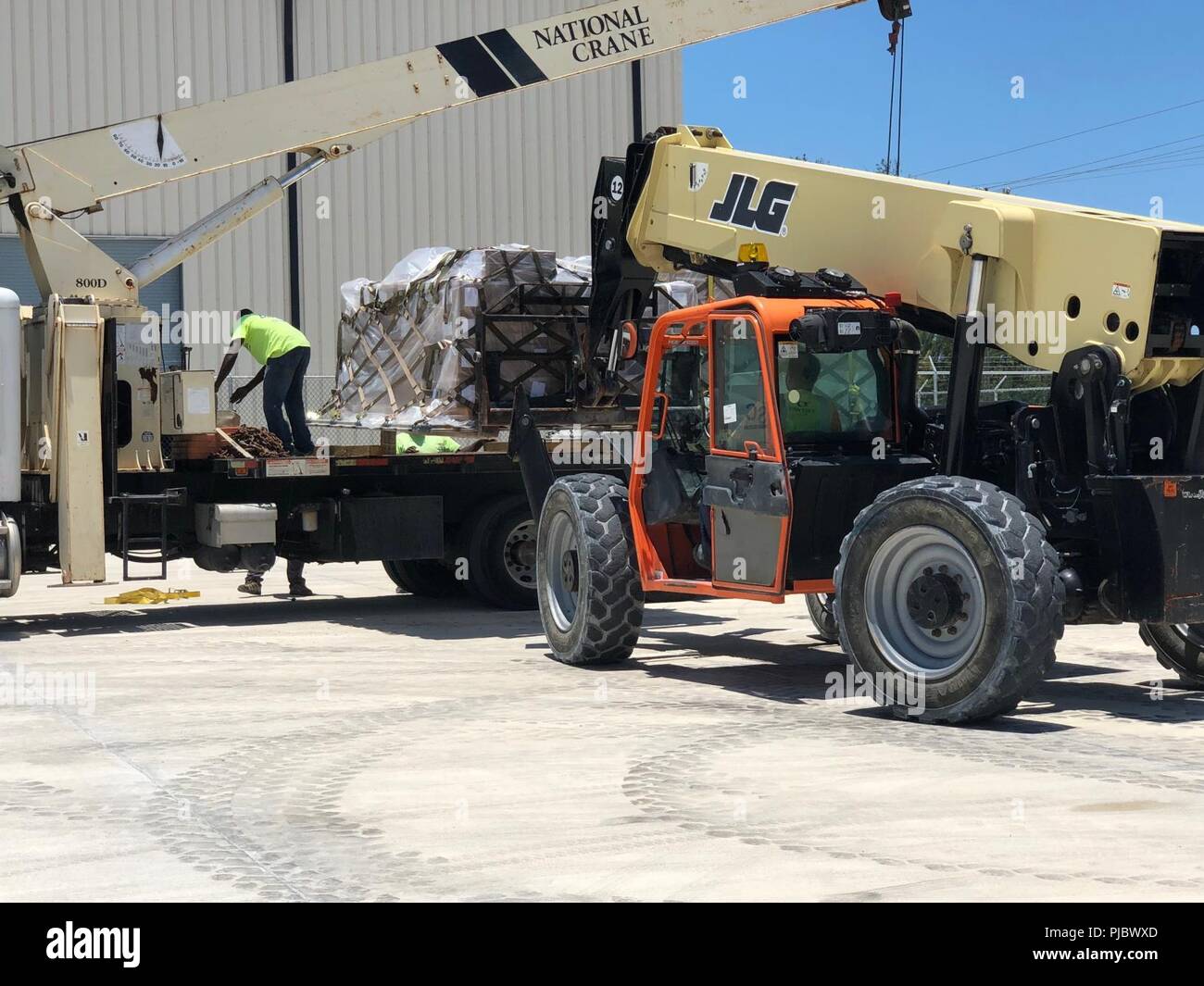 Ein Gabelstapler Einlagen einer von fünf Paletten von Lebensmitteln auf einen Lkw für Lieferung an Tradewinds 2018 trainieren die Teilnehmer in den Bahamas, 5. Juni 2018. Rund 1.700 Menschen aus 20 Ländern in dieser Übung, die darauf abzielt, die Sicherheit zu verbessern - mission Bereiche durch den gleichberechtigten Austausch von Wissen und Know-how beteiligt. Stockfoto