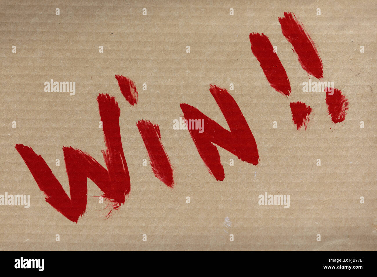 "Win!!' Hand gemalte Zeichen in Rot auf Pappe. Stockfoto