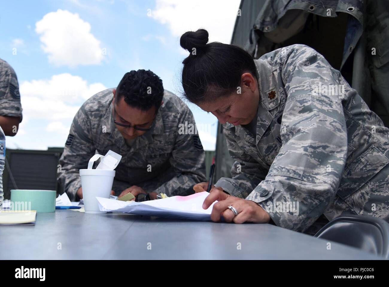 Maj. Daisy Ortiz, rechts, einen medizinischen Administration Officer, und Tech. Sgt. Orlando Velez, einem medizinischen Admin, sowohl aus der 108 WIng Medical Group, New Jersey Air National Guard, füllen Sie die Formulare für die Patienten erhielten nach einer simulierten Erdbebens während PATRIOT Nord 18 bei Volk Feld, Wis., 18. Juli 2018 aufgetreten. PATRIOT ist ein inländischer Betrieb Disaster Response Training durch die National Guard Einheiten arbeiten mit Bundes-, Landes- und lokale Emergency Management Agenturen und Ersthelfer durchgeführt. Stockfoto