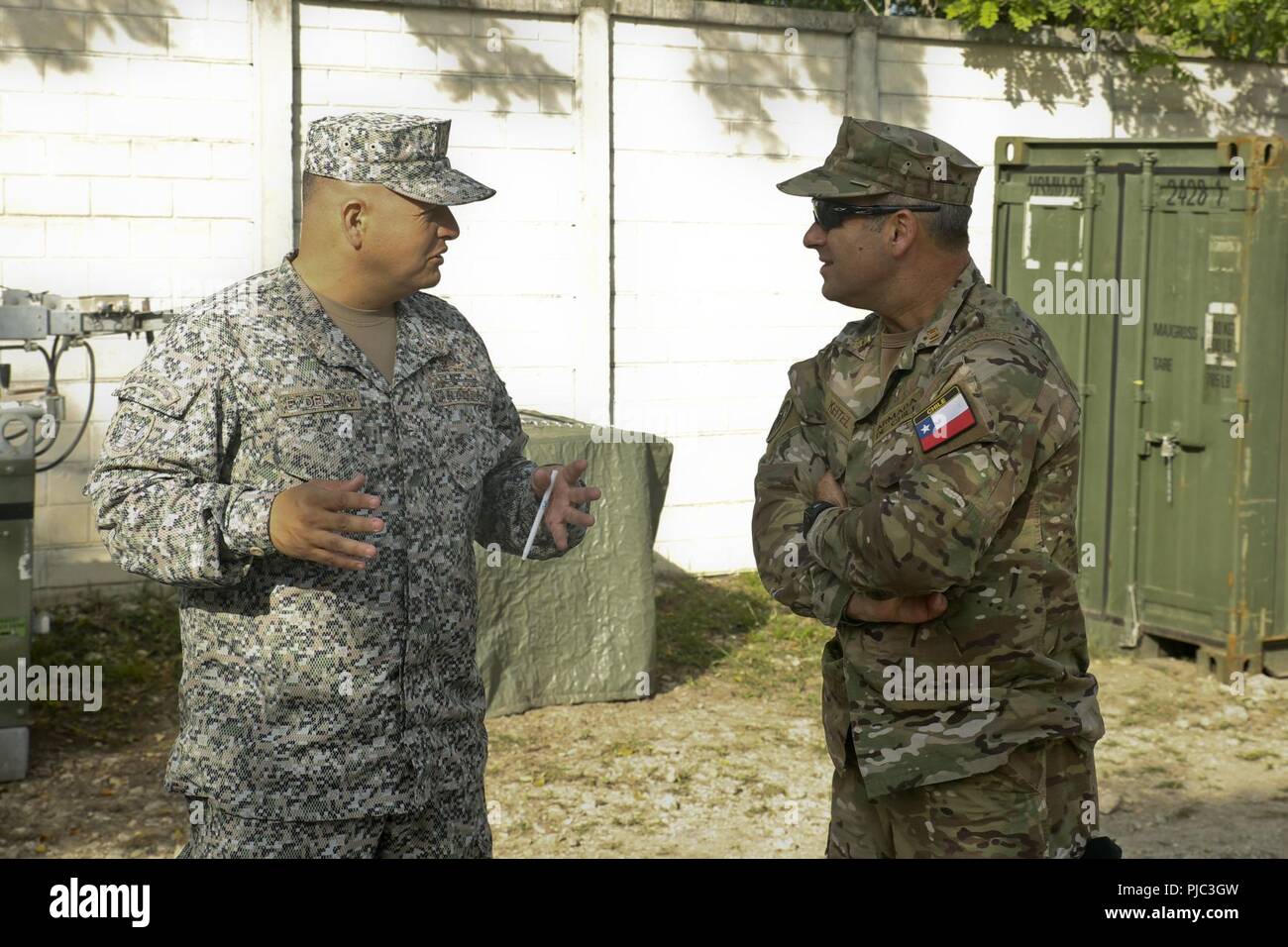 Der chilenischen Marine Kapitän Jorge Keitel, einen speziellen Berater Special Purpose Marine Air-Ground Task Force - südliche Befehl, spricht mit Kolumbianischen Marine Infanterie Oberstleutnant Erick Del Rio, der stellvertretende Kommandeur der SPMAGTF-SC, in Flores, Guatemala, 12. Juli 2018. Keitel verbindet Del Rio als ersten Partner nation Offiziere zu je einem Teil der SPMAGTF-SC-Mitarbeiter sein; der erste Schritt auf dem Weg zu einer multinationalen Amphibious task force in der Lage, humanitäre Hilfe und Katastrophenhilfe in der Region. Die Marinesoldaten und Matrosen von SPMAGTF - SC sind die Zusammenarbeit im Bereich Sicherheit Training und Engineering proj Stockfoto