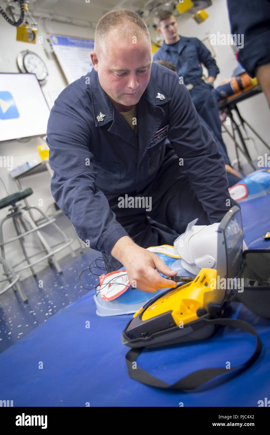 Pazifik (12. Juli 2018) Elektroniker 1. Klasse Christopher Sobkowiak, aus Peru, Illinois, gilt eine Ausbildung AED (automatisierter externer Defibrillator) während der Herz-Lungen-Wiederbelebung (HLW) Kurs in medizinischen Triage an Bord der Amphibisches Schiff USS BONHOMME RICHARD (LHD6). Bonhomme Richard ist derzeit in den USA 3 Flotte Bereich der Operationen. Stockfoto