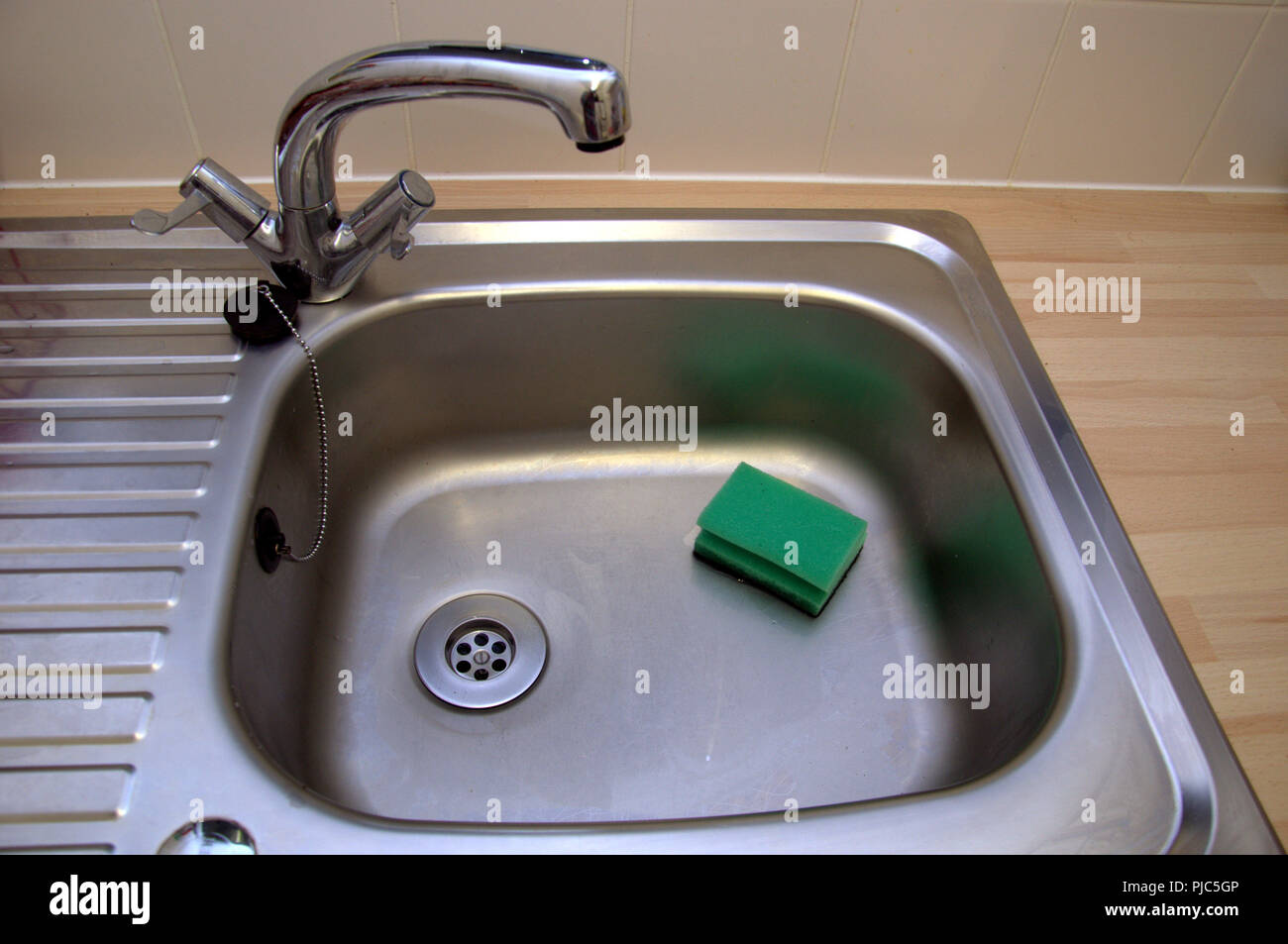 Edelstahl Spülbecken mit Mischbatterie und Abwasch Schwamm Stockfoto