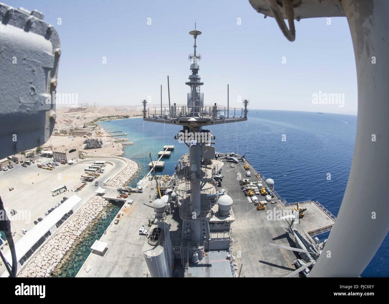 AQABA, Jordanien (9. Juli 2018) Die Wasp-Klasse amphibisches Schiff USS Iwo Jima (LHD7) sitzt pier Seite Aqaba, Jordanien. Iwo Jima ist in die USA 5 Flotte Bereich der Maßnahmen zur Unterstützung der Marine im Einsatz für die Stabilität und Sicherheit in der Region zu gewährleisten und verbindet das Mittelmeer und den Pazifischen Raum durch den westlichen Indischen Ozean und drei strategischen Punkten ersticken. Stockfoto