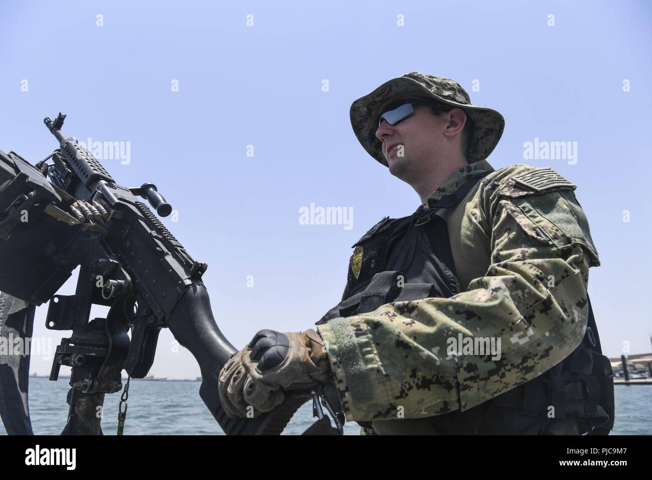 MANAMA, Bahrain (17. Juli 2018) Master-at-Arms 2. Klasse Ryan Miserendino mans ein M240 Maschinengewehr an Bord einen Hafen Sicherheit Boot zu Naval Security Force Bahrain zugeordnet. Die US-Flotte 5 Bereich der Vorgänge ist zur Unterstützung der Marineoperationen maritime Stabilität und Sicherheit in der Region zu gewährleisten und verbindet das Mittelmeer und den Pazifischen Raum durch den westlichen Indischen Ozean und drei strategischen Punkten ersticken. Stockfoto