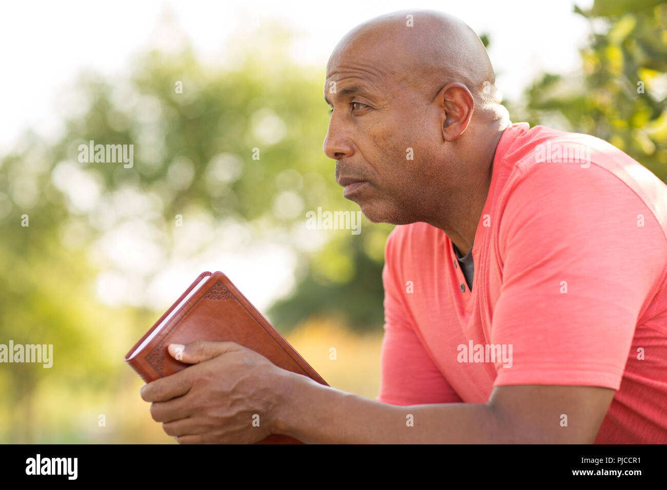 African American man beten und tief in Gedanken. Stockfoto