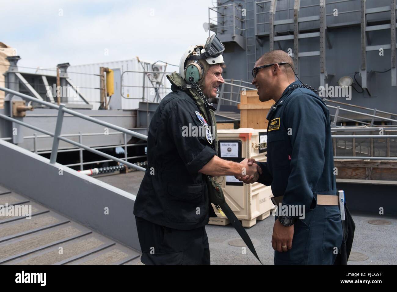 Pazifik (20 Juli 2018) Cmdr. G. J. Alota, der kommandierende Offizier der Amphibischen dock Landung Schiff USS Harpers Ferry (LSD 49), begrüßt Vice Adm. M. F.R. Lloyd, Commander, Royal Canadian Navy, auf das Schiff am 20. Juli während der Pacific Rim (Rimpac) Übung. 25 Nationen, 46 Schiffe, 5 U-Boote, über 200 Flugzeuge und 25.000 Angestellte beteiligen sich an Rimpac vom 27. Juni bis 2. August in und um die hawaiischen Inseln und Südkalifornien. Die weltweit größte internationale maritime Übung RIMPAC bietet eine einzigartige Ausbildung während der Förderung und Erhaltung Stockfoto