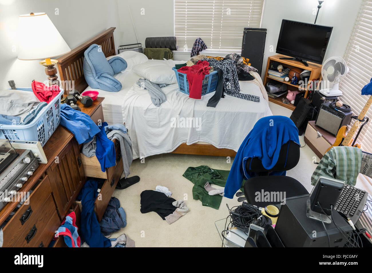 Sehr chaotisch, überladen Teenager Schlafzimmer mit Stapel von Kleidung, Musik und Sportgeräte. Stockfoto
