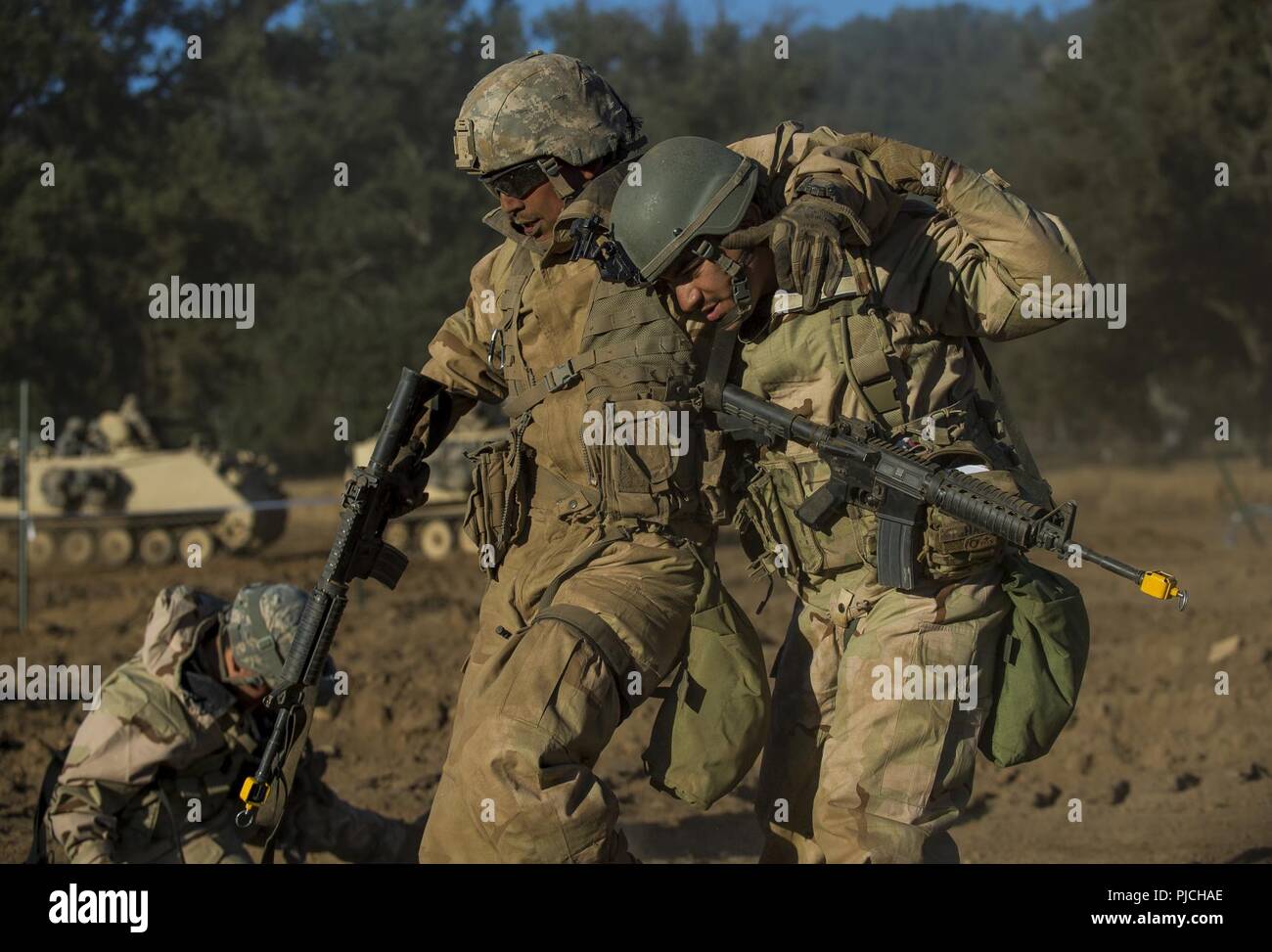 Ein U.S. Army Reserve Combat engineer Soldat aus der 350 Engineer Company, Bell, Kalifornien, hilft ein "Verwundeten" Soldat zurück in die hintere während einer kombinierten Waffen Verletzung zu einem Combat Support Training (CSTX) am Fort Hunter Liggett, Kalifornien, 22. Juli 2018. Diese Drehung der CSTX läuft durch den Monat Juli, Ausbildung Tausende von Soldaten der US-Army Reserve von einer Vielzahl von Funktionen, die mit der Militärpolizei, Medizin, Chemie, Logistik, Transport und vieles mehr gehören. Stockfoto