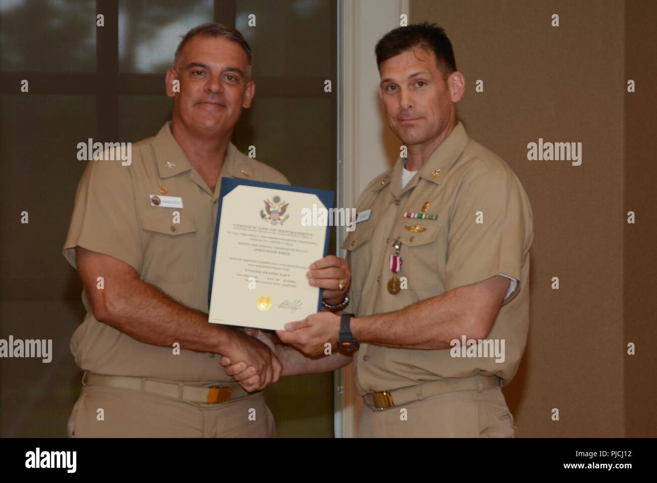 Der Master Chief James Baker, erhält ein Zertifikat, das der Ruhestand vom kommandierenden Offizier CAPT James Hancock, Naval Medical Center Camp Lejeune, während seinen Ruhestand Festakt in Marston Pavillon an Bord Marine Corps Base Camp Lejeune am 13. Juli 2018. Baker diente 30 Jahre lang in der United States Navy. Seine Karriere fast zwei Jahrzehnte als einen speziellen Amphibious Reconnaissance Corpsman. Baker's neueren Rolle war Command Master Chief bei NMCCL. Stockfoto