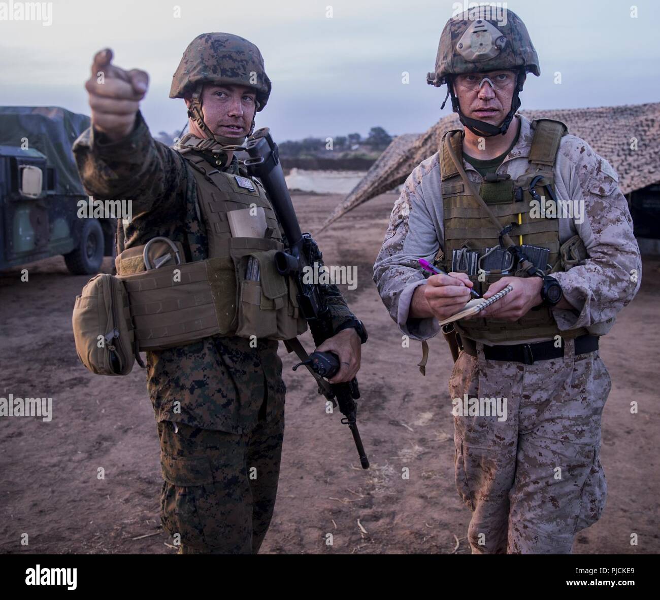 Marine Corps Base Camp Pendleton, Kalifornien - Sgt. Isaac Engelbrektson, (links) eine Bekämpfung der Ingenieur mit der Bekämpfung der Logistik Bataillon 11, 1 Marine Logistics Group, erklärt einer simulierten Geiselnahme und Lage, Gunnery Sgt. Samuel Wright, eine Beseitigung von Explosivstoffen Techniker mit CLB-11, während einer Marine Corps Combat Readiness Evaluation an Bord Camp Pendleton, Calif., Juli 19. Diese Schulung Szenario erforderlichen EOD-Spezialisten zu diffus und Entsorgung von Explosivstoffen in der Nähe der Geiseln vor der Rettung. Stockfoto