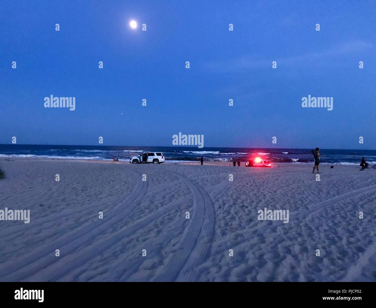 Lokale EMS und weitere Rettungskräfte eintreffen zum Strand von Fire Island, New York, 24. Juli 2018. Am Abend, ein dienstfreier Coast Guard Mitglied zwei distressed Schwimmer gerettet. Stockfoto