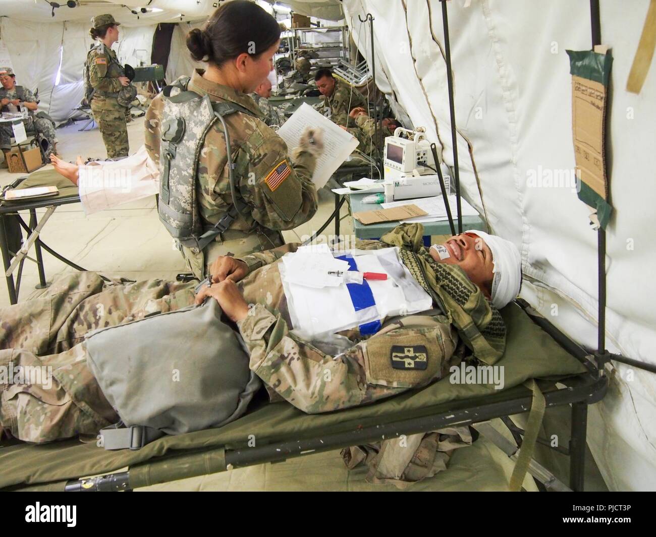 Us-Armee Reservisten mit 228Th Combat Support Hospital, gegründet aus San Antonio, Texas, für die medizinische Versorgung für eine simulierte Patienten in einem chirurgischen Schnitt Anzug während der globalen Medic CSTX 91-18-01, am Fort Hunter Liggett, Kalifornien, 21. Juli 2018. CSTX 91-18-01 ist ein Kampf Support Training übung, die sicherstellt, dass America's Army Reserve Einheiten und Soldaten ausgebildet sind und bereit, auf kurze bereitstellen - Bekanntmachung und fähig, Bekämpfung bereit, und tödlichen Fähigkeiten zur Unterstützung der Armee und unsere gemeinsamen Partner überall in der Welt. Stockfoto