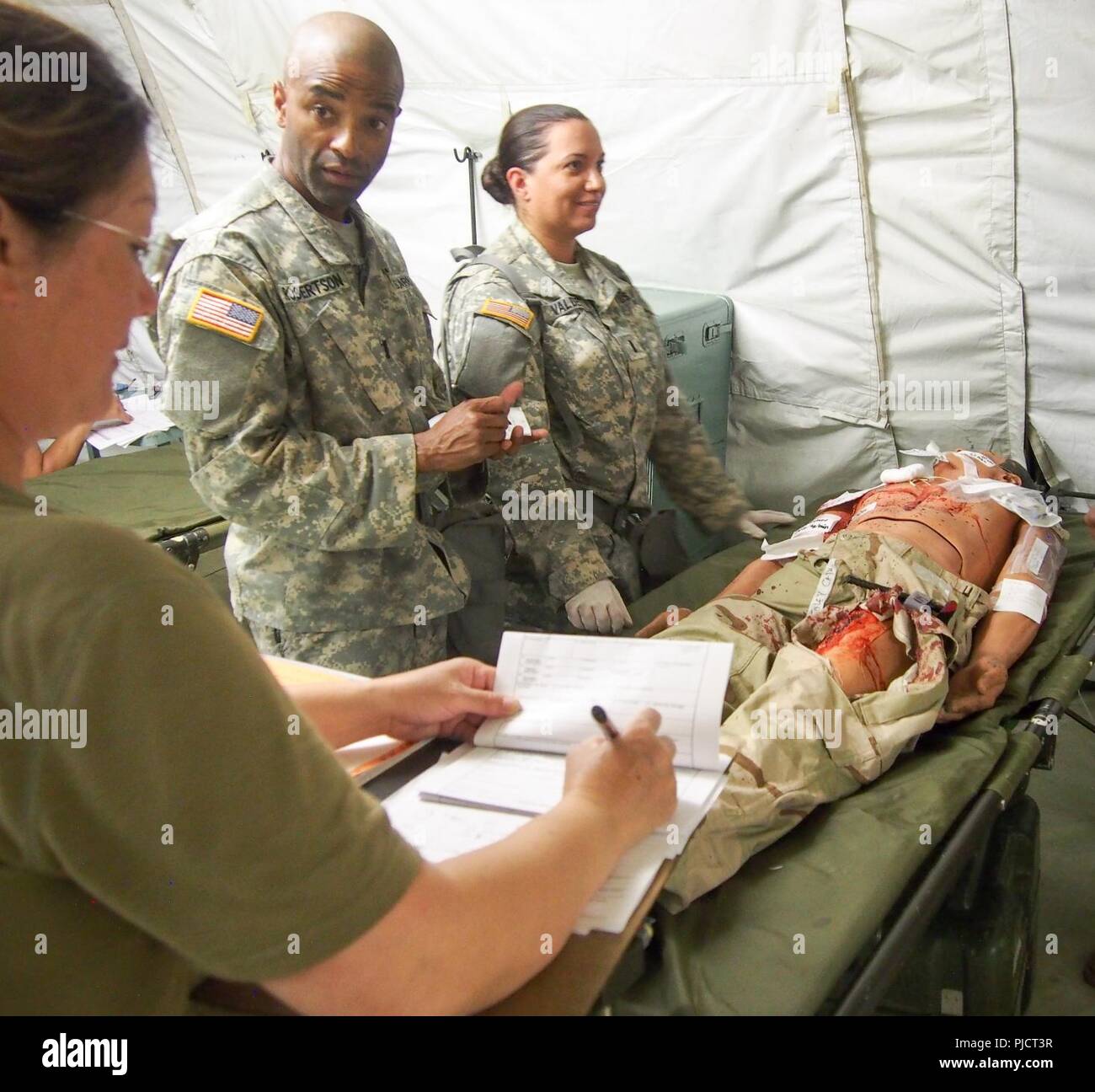 Us-Armee Soldaten zu Buchen 228th Combat Support Hospital zugewiesen, basierend aus San Antonio, Texas, für die medizinische Versorgung für eine simulierte Patienten während der Global Medic CSTX 91-18-01, am Fort Hunter Liggett, Kalifornien, 21. Juli 2018. CSTX 91-18-01 ist ein Kampf Support Training übung, die sicherstellt, dass America's Army Reserve Einheiten und Soldaten ausgebildet sind und bereit, auf kurze bereitstellen - Bekanntmachung und fähig, Bekämpfung bereit, und tödlichen Fähigkeiten zur Unterstützung der Armee und unsere gemeinsamen Partner überall in der Welt. Stockfoto
