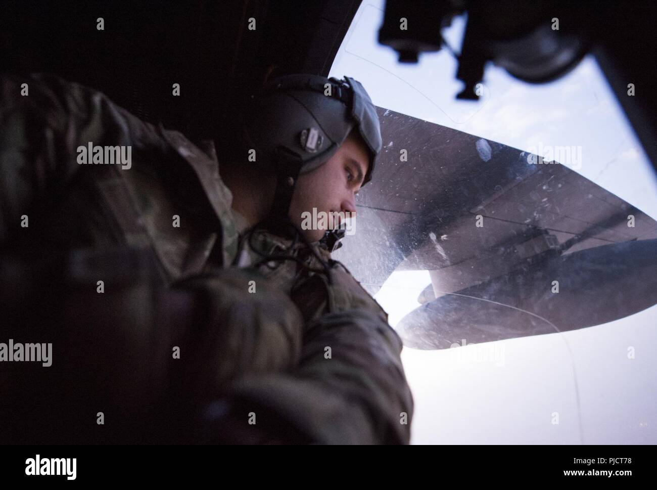 Eine besondere Mission Aviator 16 Expeditionary Special Operations Squadron zugeordnet blickt eine Tür Fenster eine AC-130 W Stinger II während einer Mission über den Irak, 23. Juli 2018 an Bord. Die AC-130 W Stinger II bietet Unterstützung aus der Luft zu US- und Koalitionstruppen im Irak und Syrien zur Unterstützung der Operation inhärenten Lösen. Die Koalition ist die ISIS zusammengeschlossen, um Kräfte zu besiegen, indem sie Unterstützung aus der Luft auf dem Schlachtfeld. Stockfoto