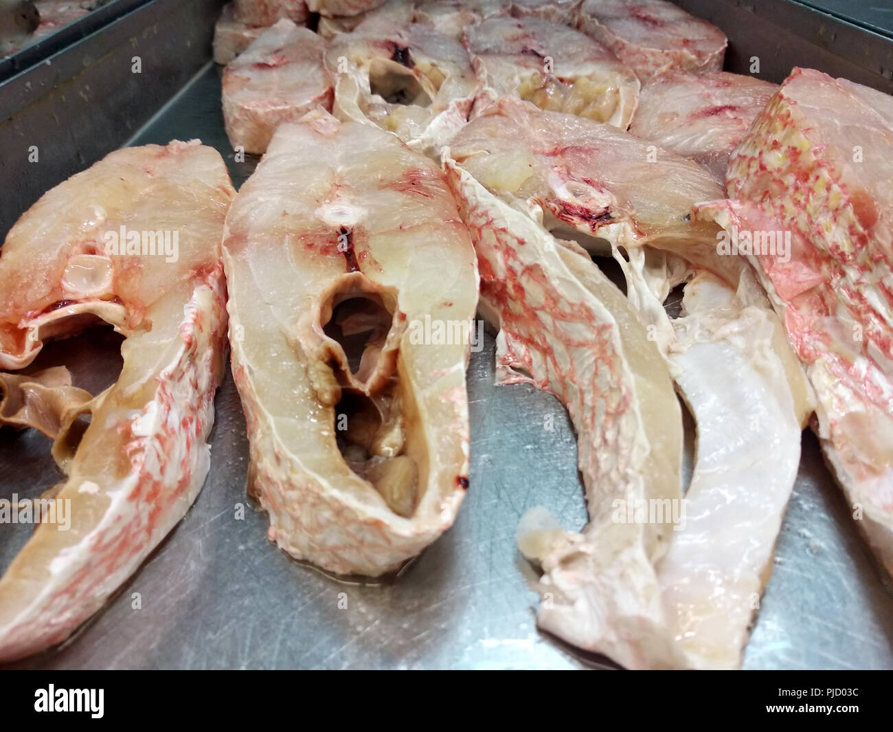 Fisch, Fleisch, das geschnitten wurde und auf einem aus Edelstahl zum Verkauf gestellt. Stockfoto
