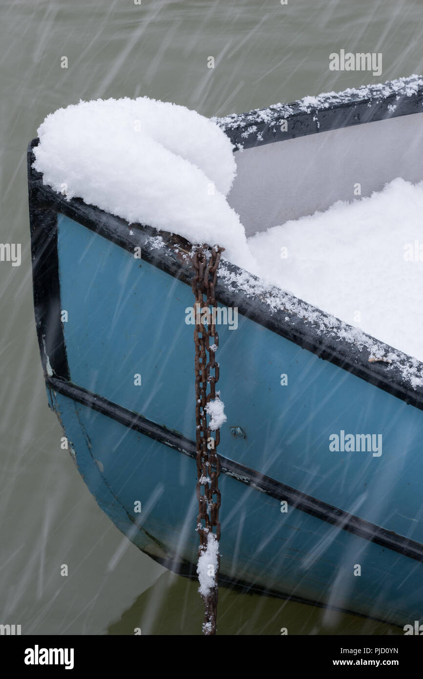 Schwere fallenden Schnee auf blau Boot vertäut Teil ausgefüllt mit Schnee, auf der Themse, Egham, Surrey Stockfoto