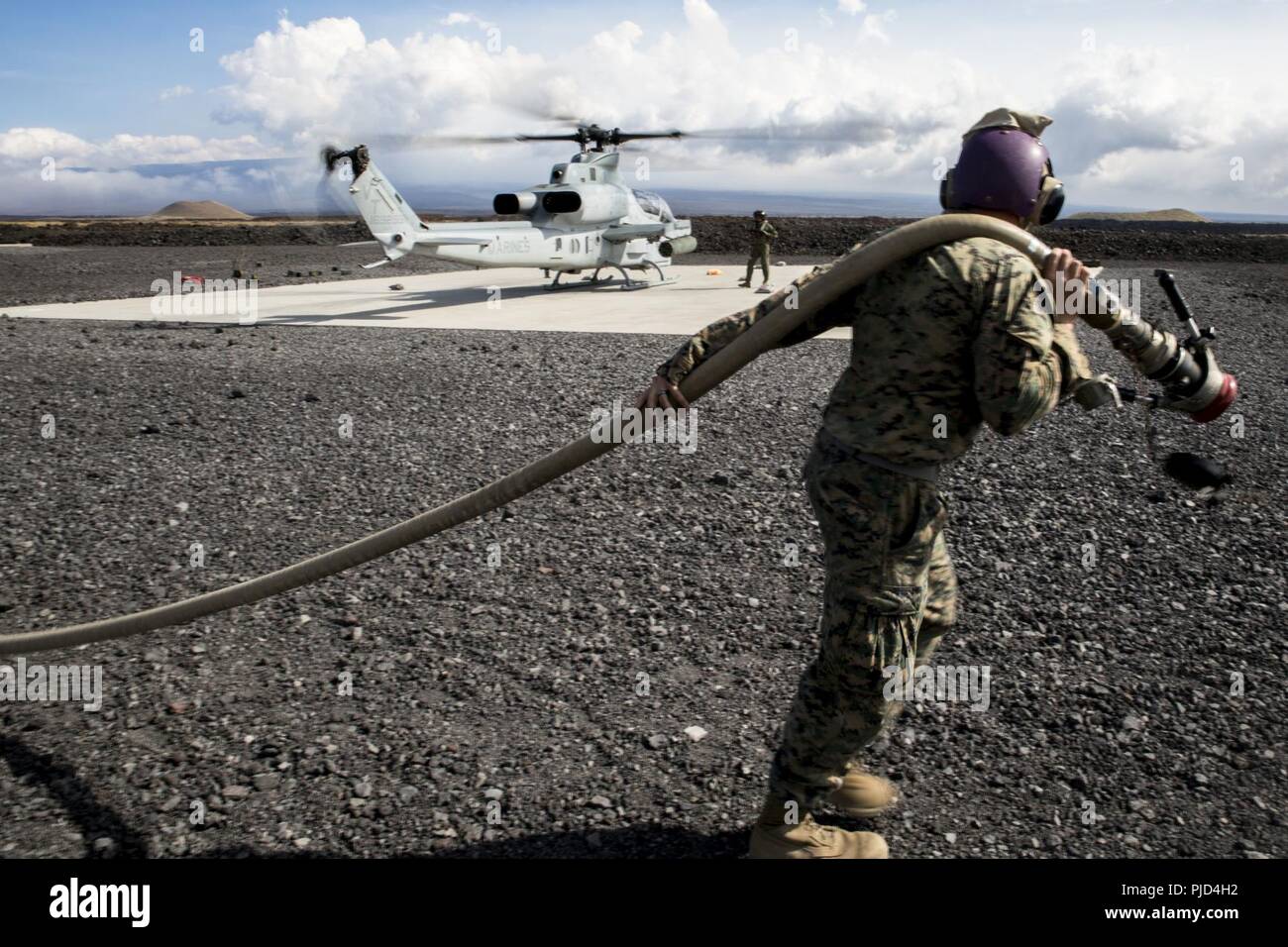 POHAKULOA TRAINING AREA, California (18. Juli 2018) US Marine Corps Cpl. Garrett Subik, ein Großteil der Spezialist mit Marine Wing Support Abteilung 24, bewegt sich eine Kraftstoffleitung auf dem Weg zu einem Landeplatz, um während eines Field Test für eine Expeditionary Mobile Kraftstoff Additization Fähigkeit System starten eine AH-1W Super Cobra Helikopter als Teil der Felge des Pazifiks (Rimpac) Übung an Pohakuloa Training Area, California, 18. Juli 2018. RIMPAC bietet hochwertige Ausbildung für Task-organisiert, leistungsfähigen Marine Air-Ground Task Force und erhöht die kritische Reaktion auf Krisen Fähigkeit der US-Marines in Stockfoto