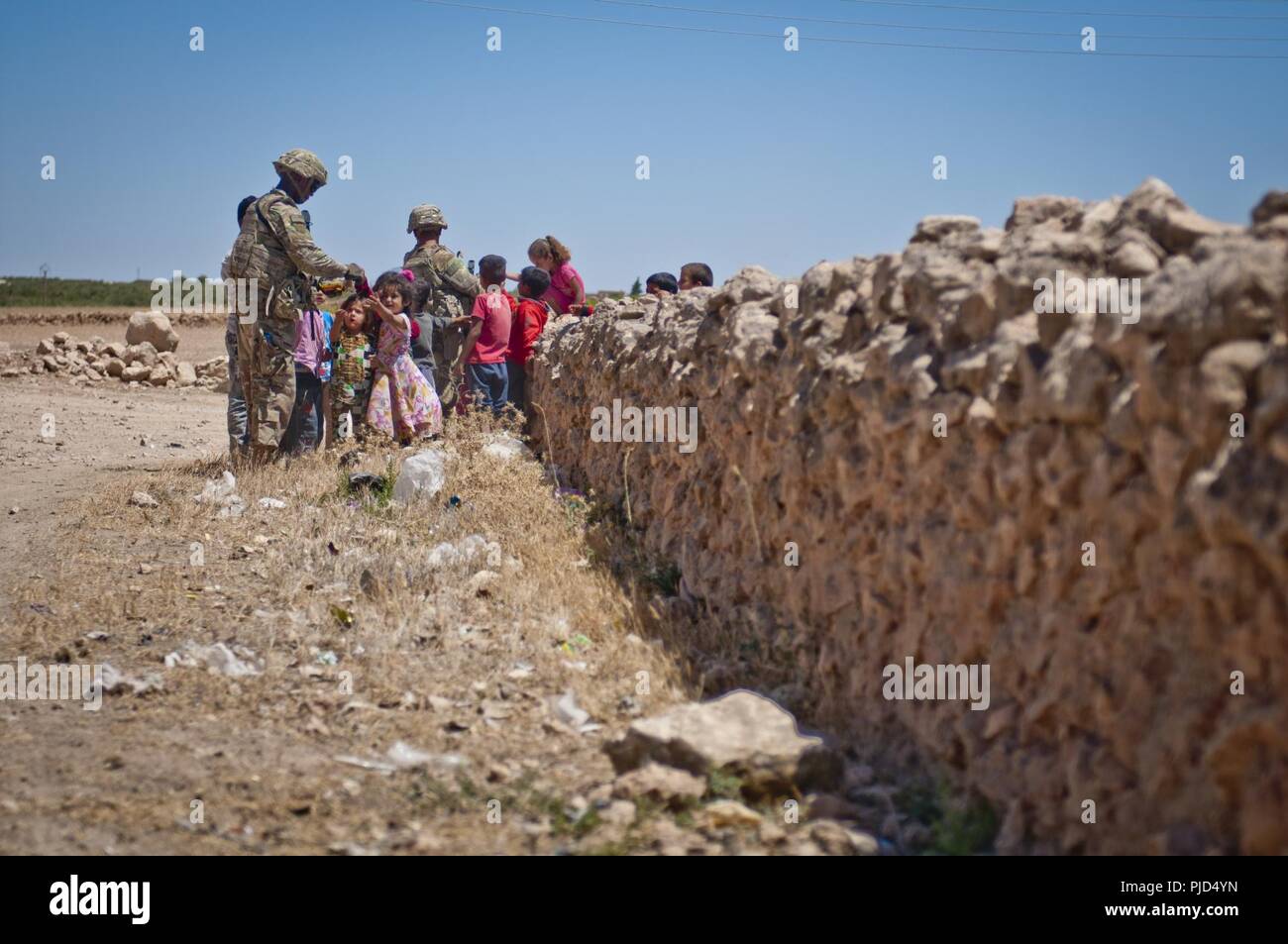 Us-Soldaten Interaktion mit Kinder während ihrer unabhängigen, koordinierten Patrouille in einem Dorf entlang der Demarkationslinie außerhalb Manbij, Syrien, 16. Juli 2018. Die US-amerikanischen und türkischen Militärs führen diese Patrouillen für die Sicherheit und die Sicherheit in der Region zu verstärken. Stockfoto