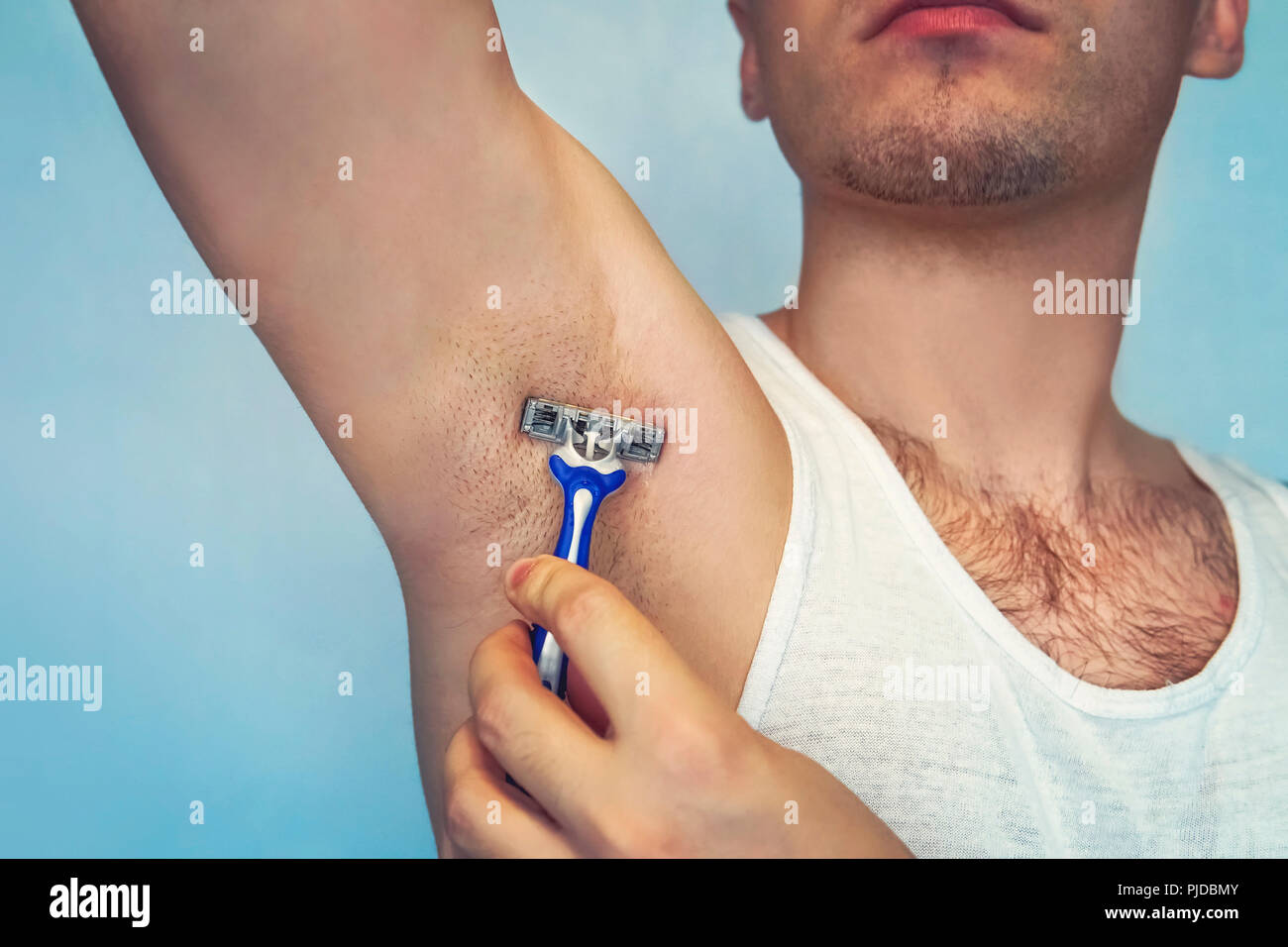 Achsel Haarentfernung. Männliche Depilation. Junge attraktive muskulösen  Mann mit rasiermesser Haar aus seinem Körper zu entfernen. Die self-care  Konzept. Epilieren Stockfotografie - Alamy