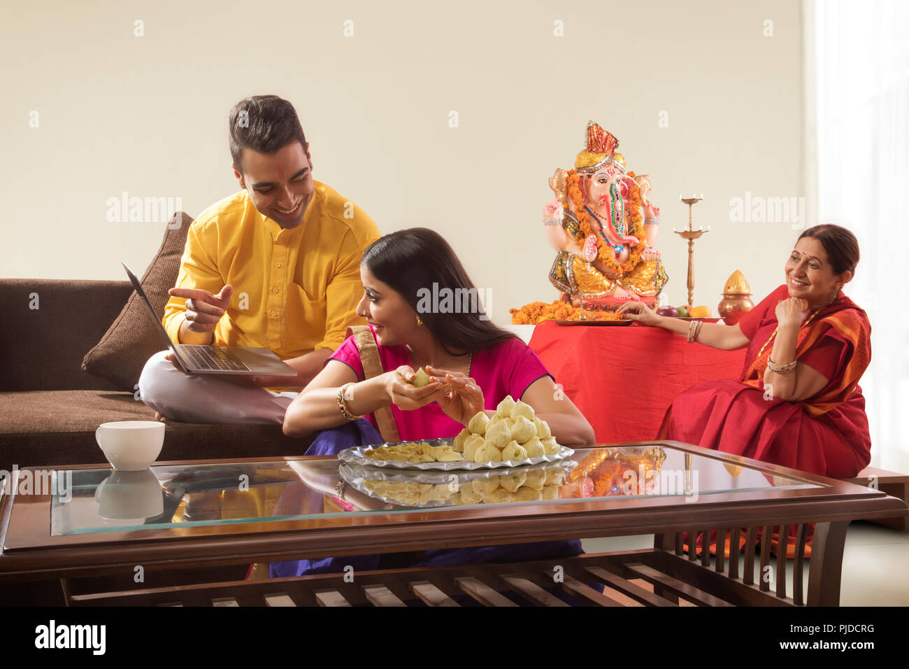 Mann Frau zusammen zu sitzen, während Frau macht modaks und Mann ihr Laptop angezeigt Stockfoto
