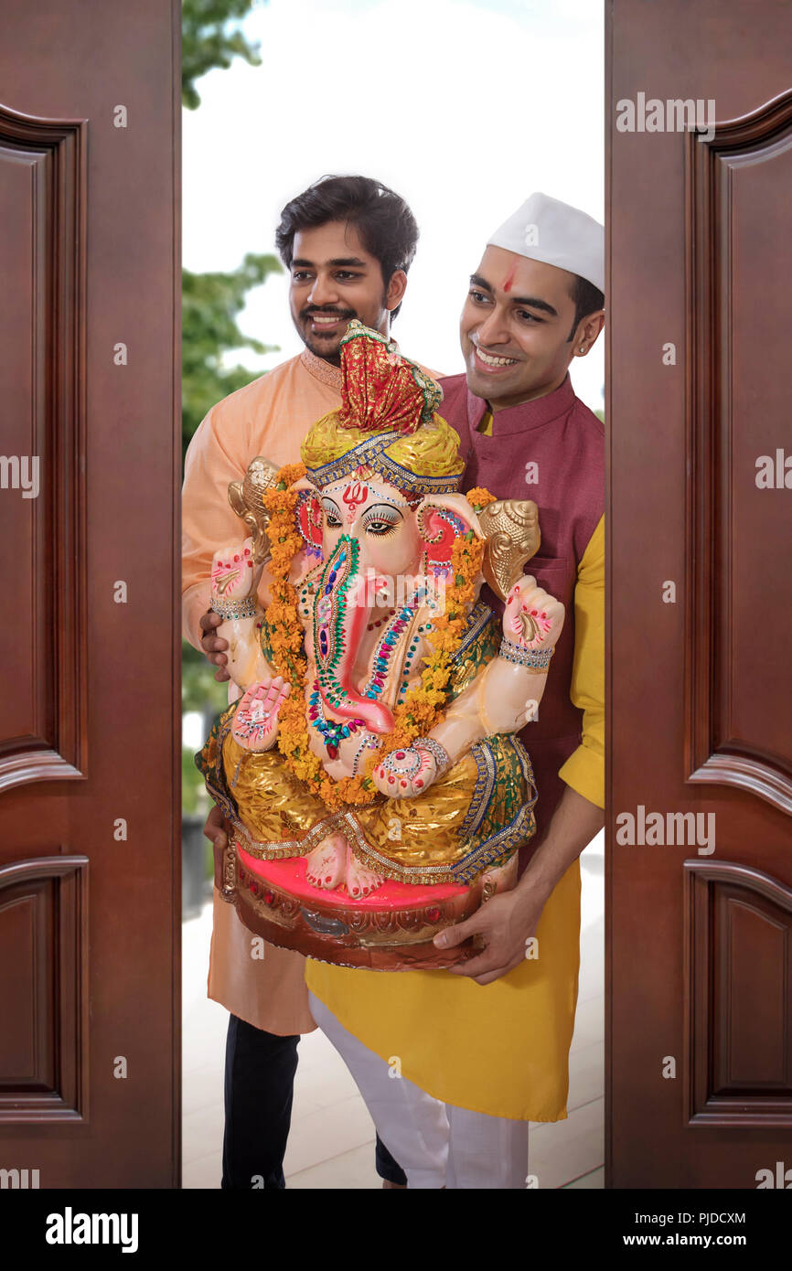 Männer bringen Ganpati Haus anlässlich von Ganesh Chaturthi Stockfoto