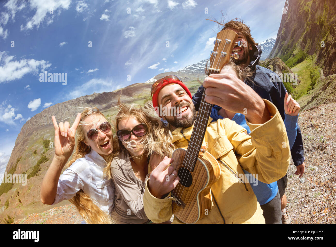 Glücklich, Freunde, Spaß haben, Gitarre spielen im Freien Stockfoto