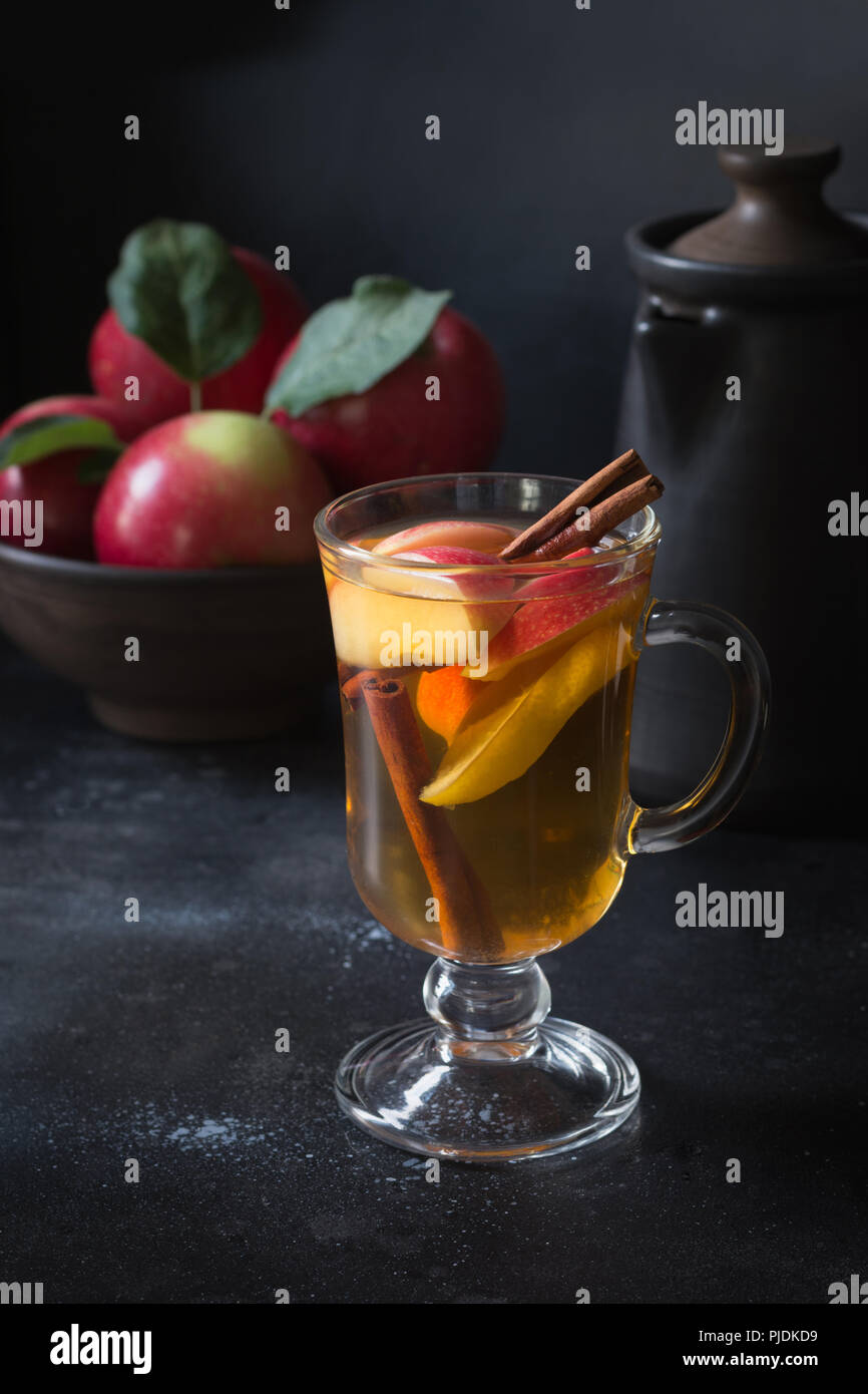 Glas Tee mit Zitrone, gewürzt, in Scheiben geschnittenen Apfel und Zimt auf dem Schwarzen Brett. Close Up. Herbst noch leben. Stockfoto