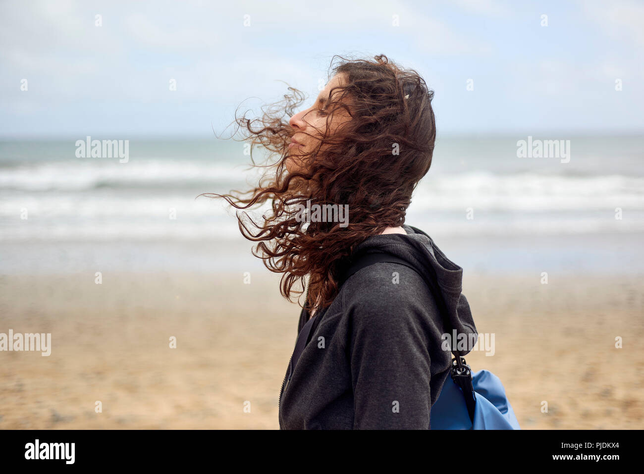 Weibliche Touristen mit Flyaway Haar am Strand, Las Palmas, Gran Canaria, Kanarische Inseln, Spanien Stockfoto
