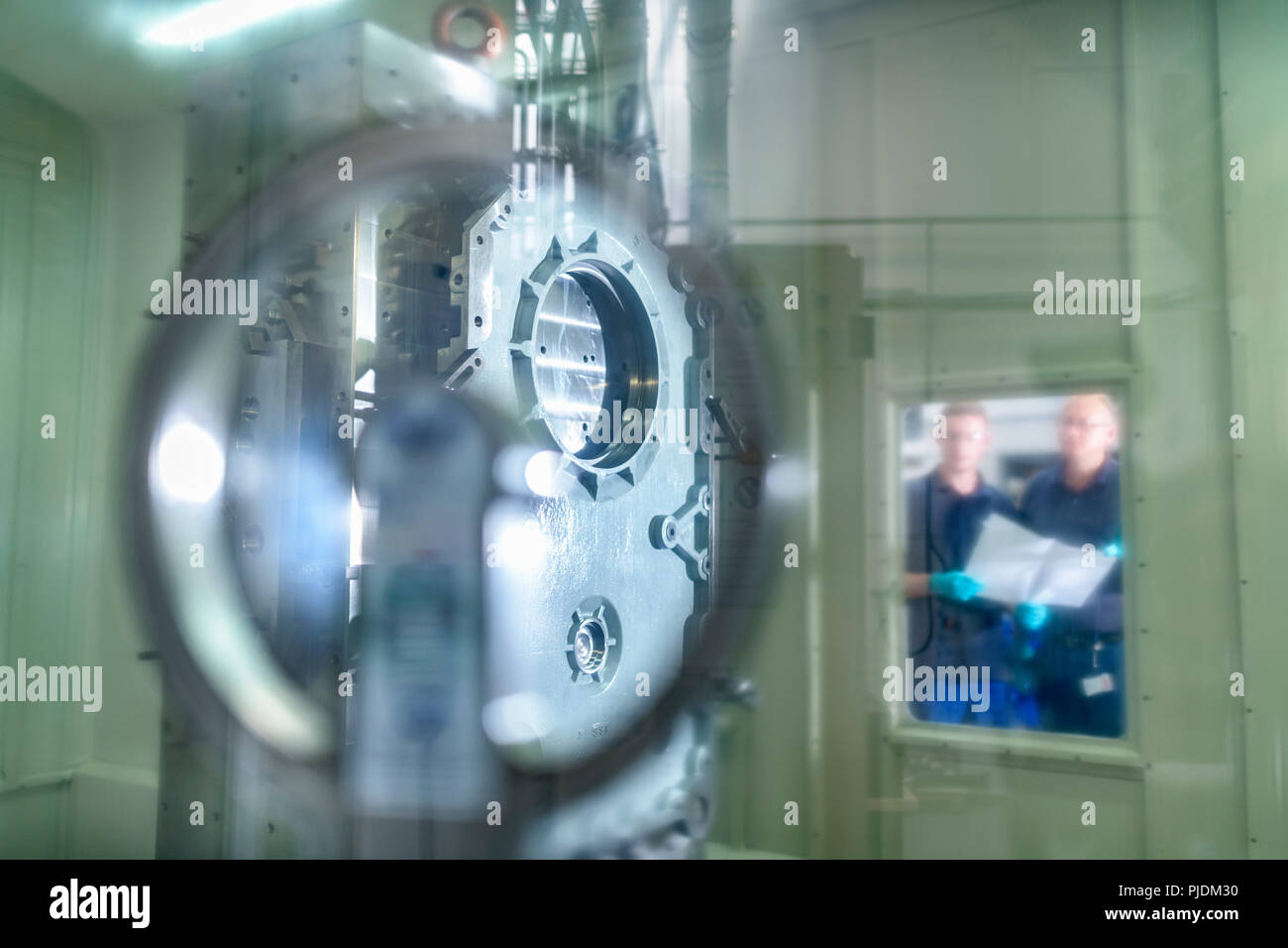 Ingenieure anzeigen Teil in CNC-Maschine im Getriebe ab Werk Stockfoto