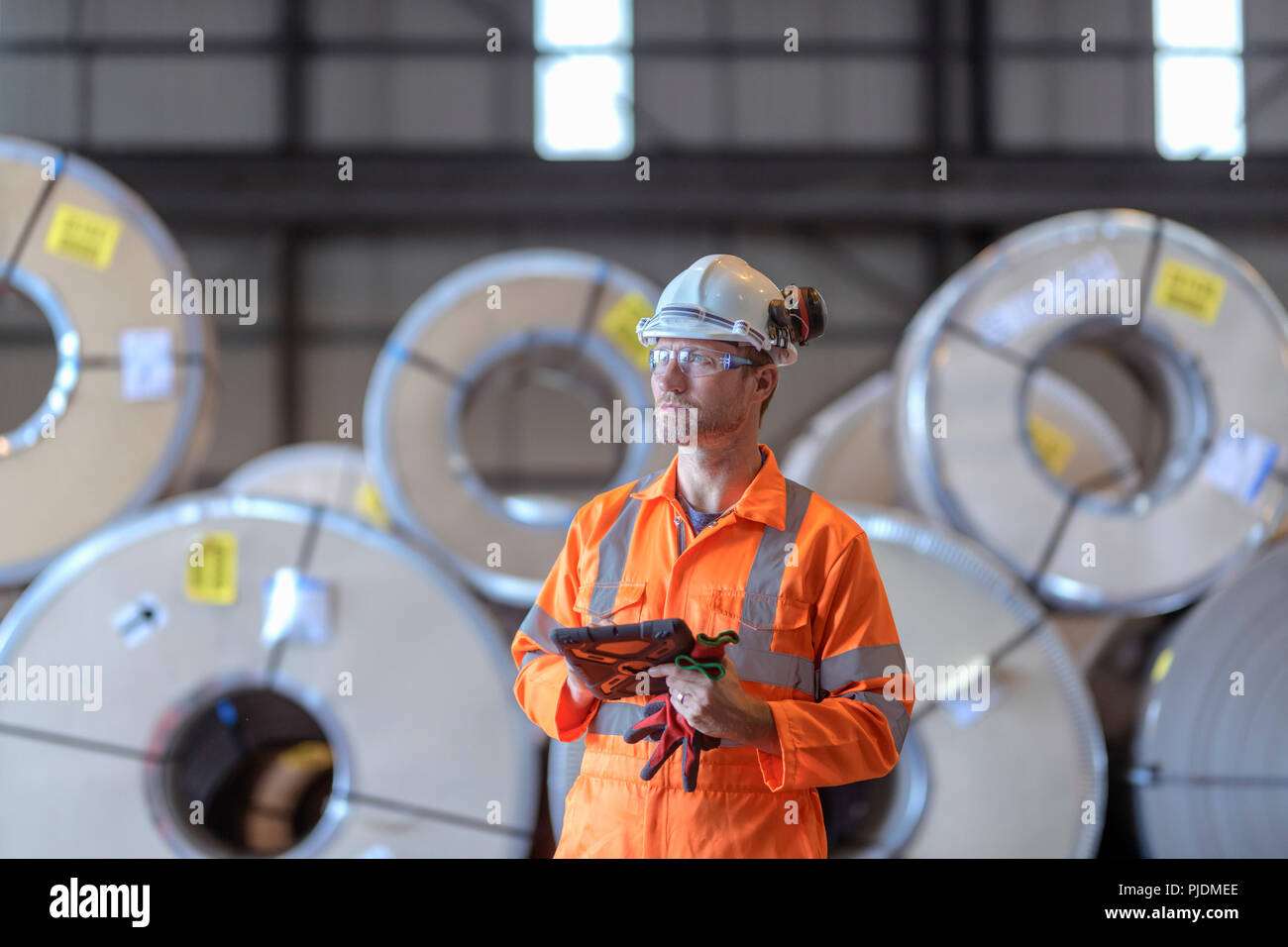 Portrait der digitalen Tablet von Zeilen aus Stahlblech in der Lagerung im Hafen Arbeiter Stockfoto