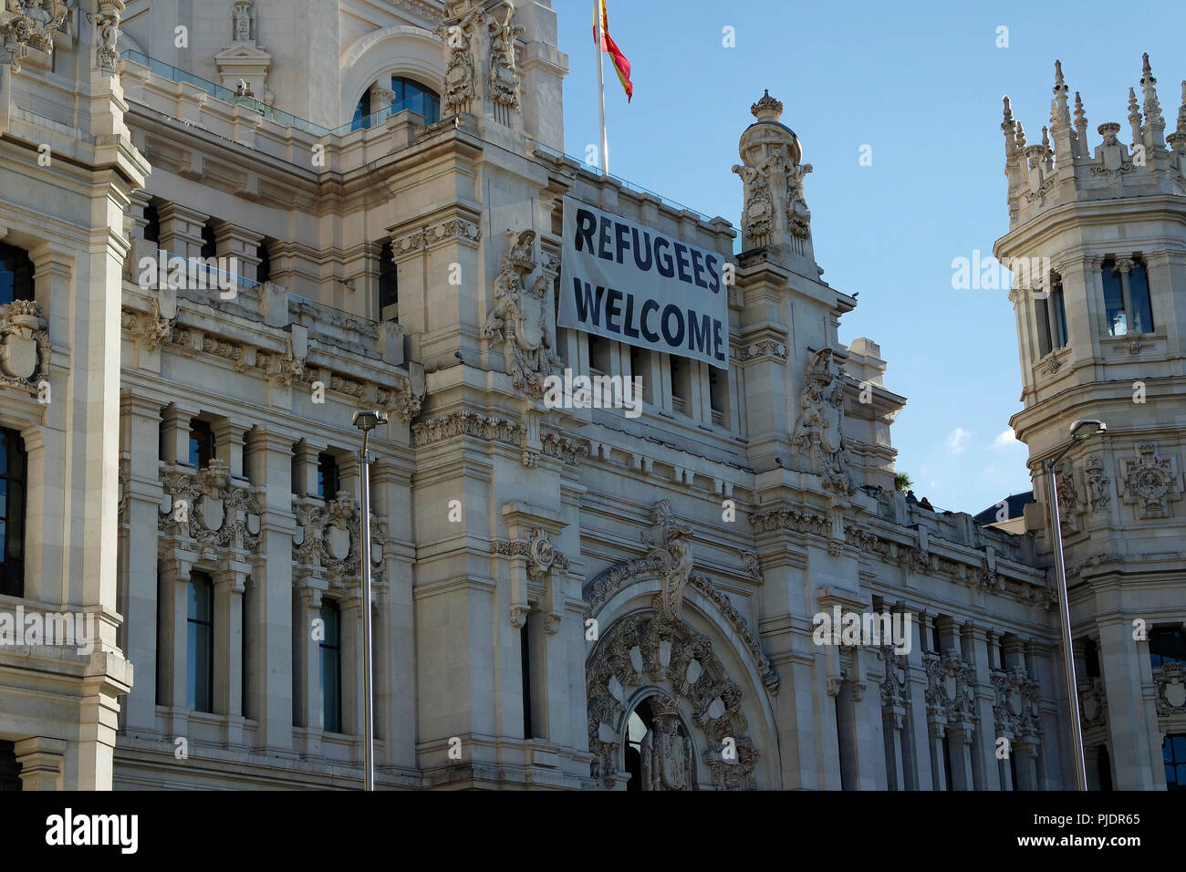 Politischen Slogan 'Flüchtlinge Willkommen "am Palacio de Communicaciones, Madrid. Stockfoto