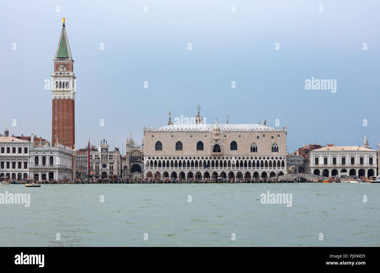 San Marcos Platz in Venedig, vom Meer aus gesehen mit Hunderten von Touristen zu Fuß auf den Rand der Lagune Stockfoto