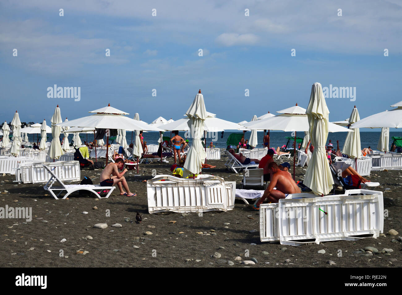 Sochi, Russland - Juni 5. 2018 Leute am Strand mit Sonnenschirmen und Liegestühlen. Stockfoto