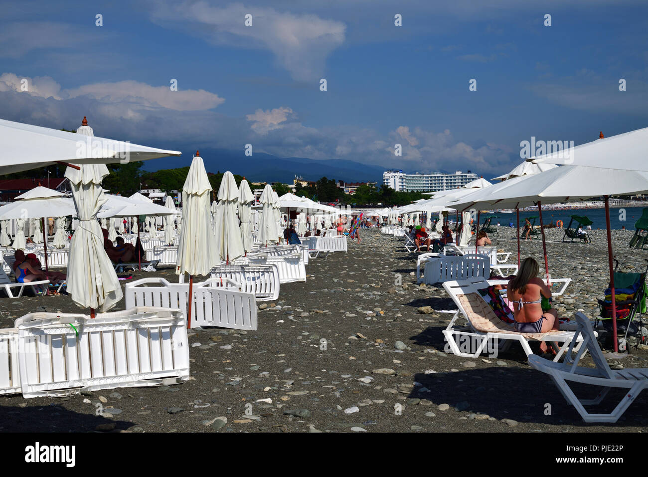 Sochi, Russland - Juni 5. 2018 Leute am Strand mit Sonnenschirmen und Liegestühlen. Stockfoto