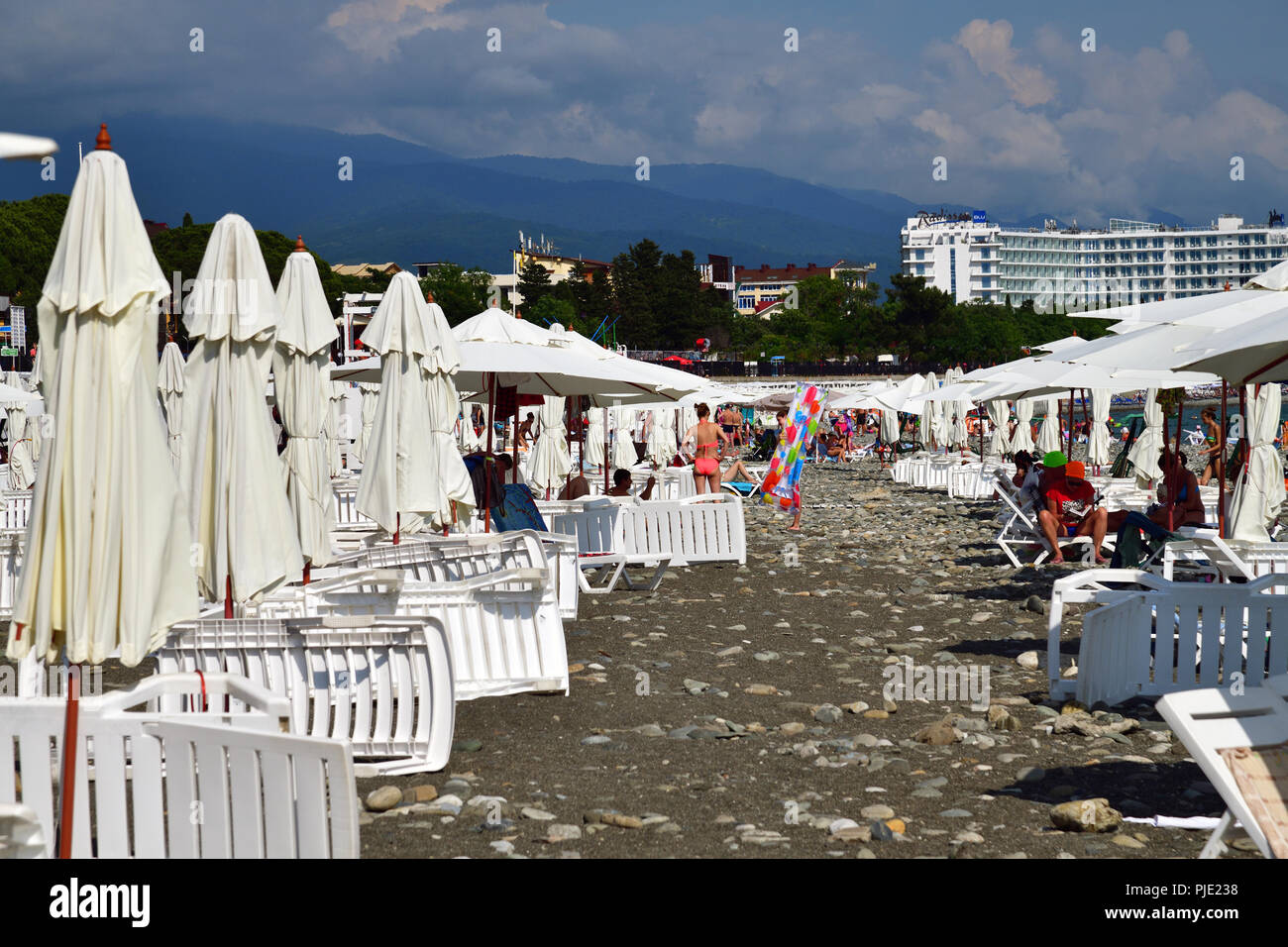 Sochi, Russland - Juni 5. 2018 Leute am Strand mit Sonnenschirmen und Liegestühlen. Stockfoto