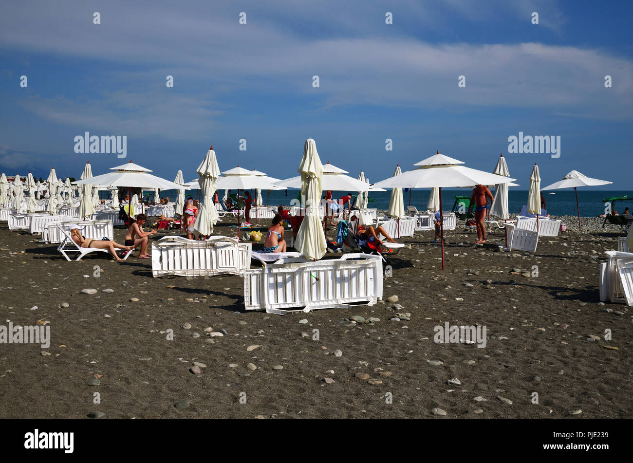 Sochi, Russland - Juni 5. 2018 Leute am Strand mit Sonnenschirmen und Liegestühlen. Stockfoto